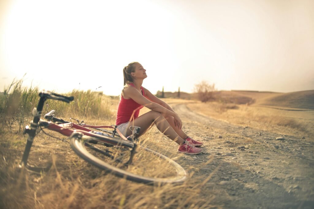 pexels-photo-3771836-3771836 Full body of female in shorts and top sitting on roadside in rural field with bicycle near and enjoying fresh air with eyes closed