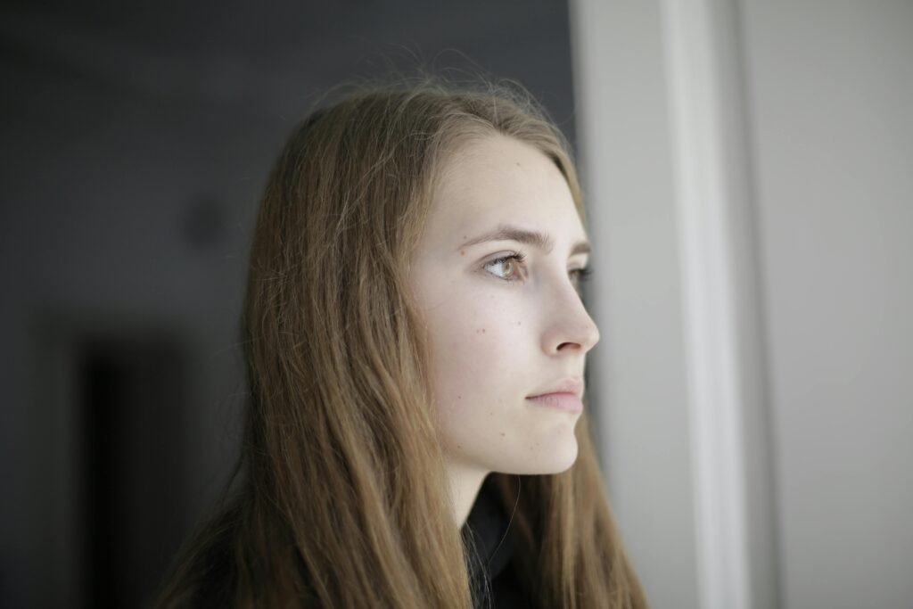 Pensive young woman in living room